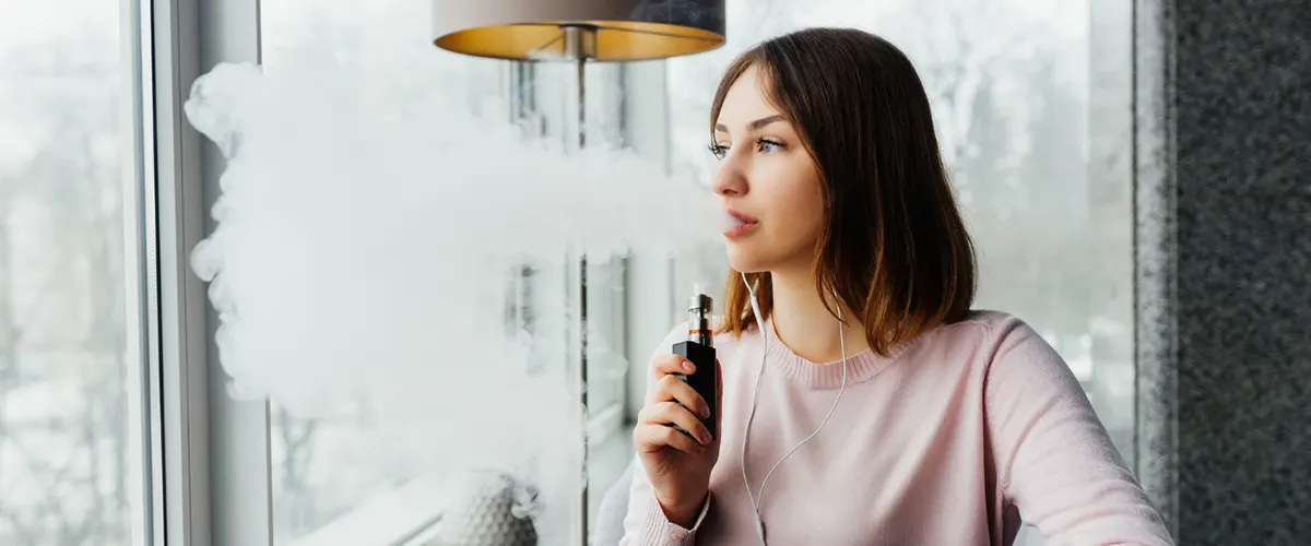 woman is vaping after fully charging her rechargeable disposable vape