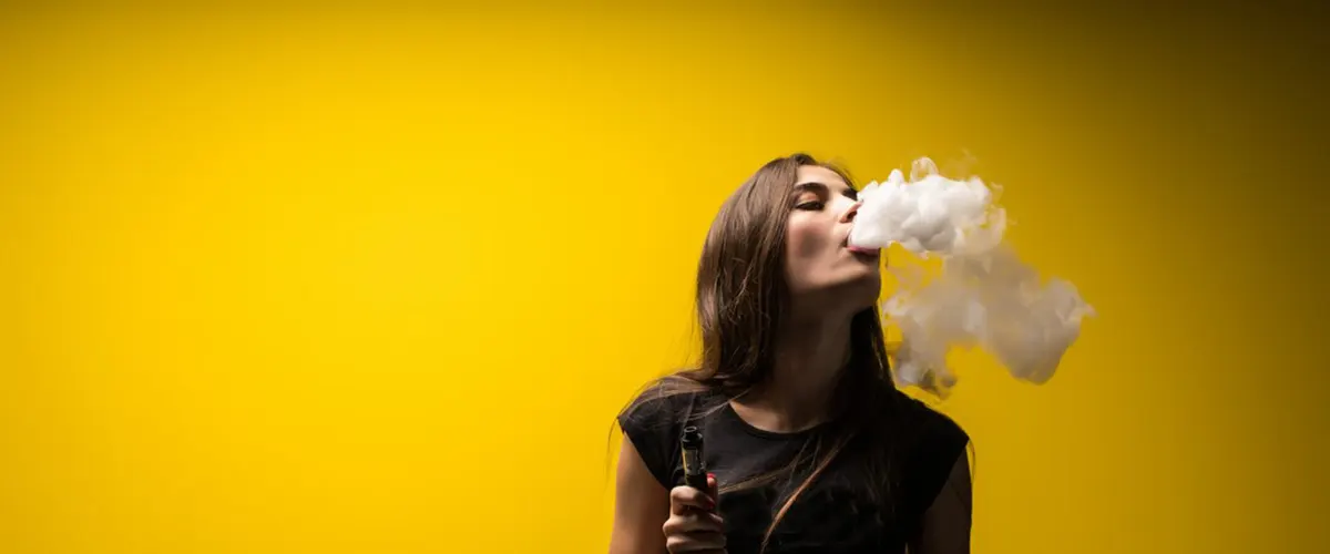 woman standing vaping after making her disposable vape work