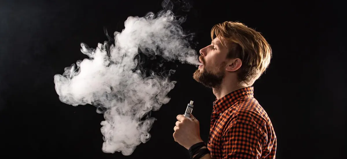 man with beard and stylish hairstyle enjoy vapor of disposable vape