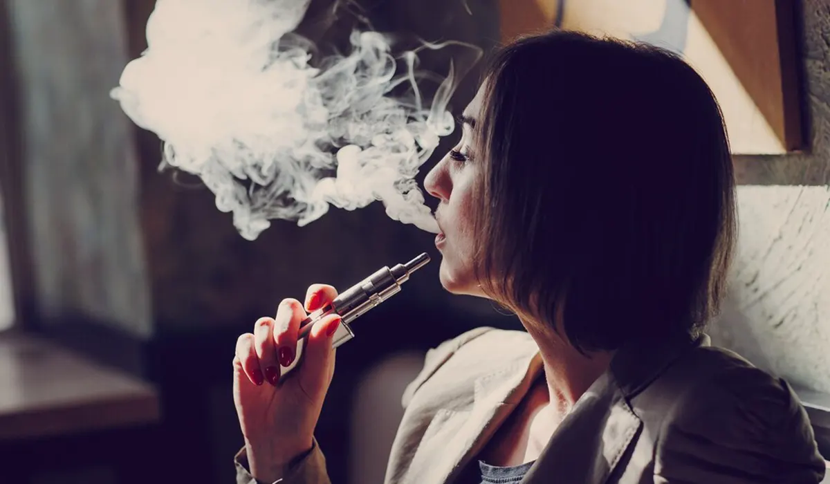 woman smoking vapor from disposable vapes