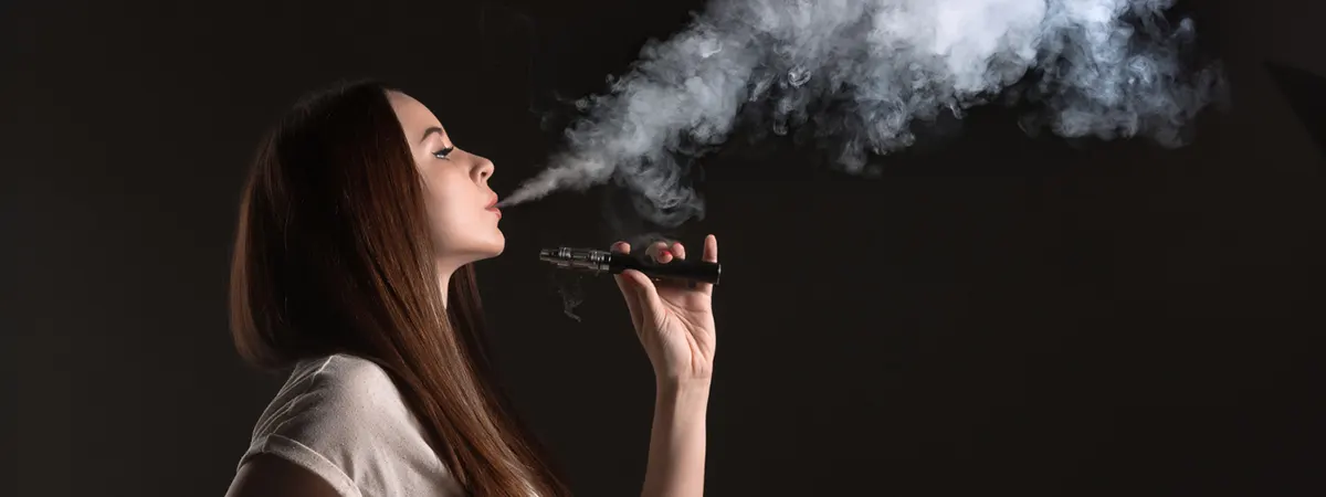 cool vaping woman in black studio